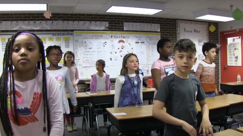 A classroom full of students standing.