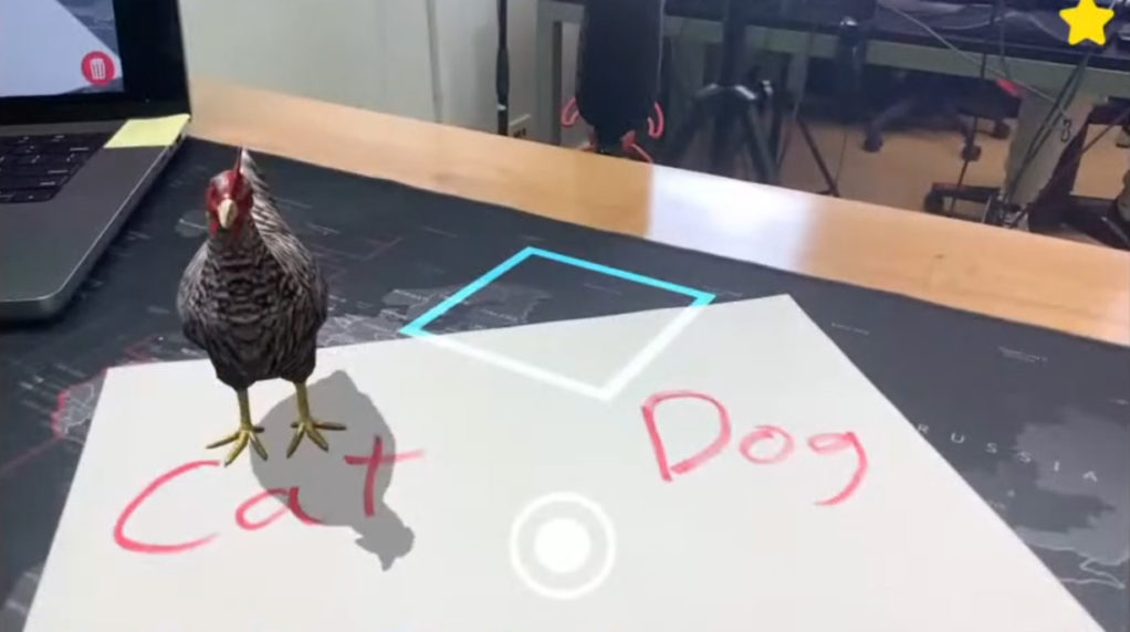 A virtual chicken standing on a sheet of paper.