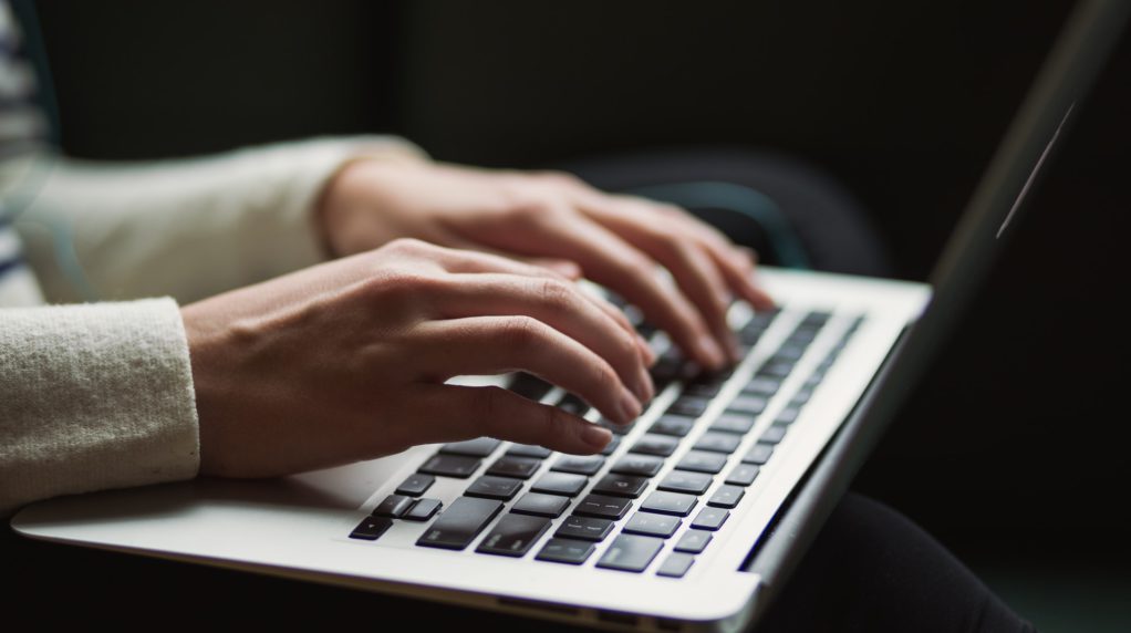 Hands typing on a keyboard.